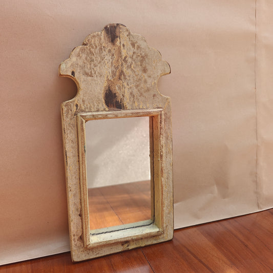 Close-up of mottled antique patina finish on wood mirror frame