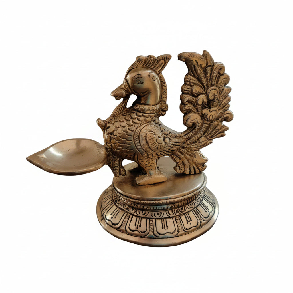 Handcrafted antique brass peacock diya with natural patina, single petal-shaped oil reservoir and engraved circular base