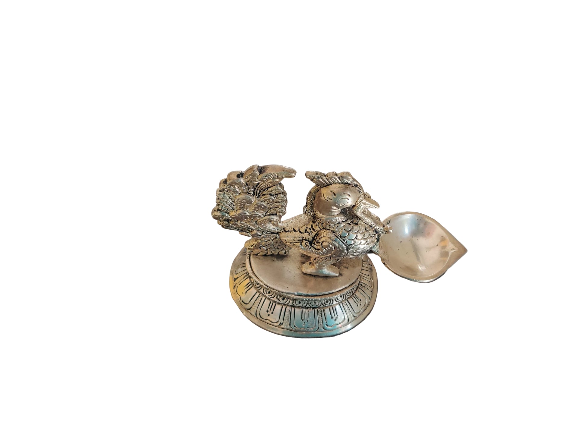 Top view of antique brass peacock oil lamp showing fanned tail feathers and detailed scale work with natural patina