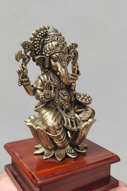 Close-up of brass Ganesha idol showing crown and jewellery details
