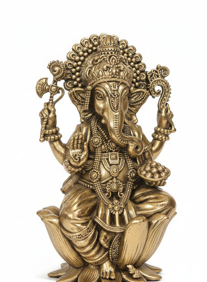 Brass Ganesha idol on decorative base styled on wooden surface with decor accessories