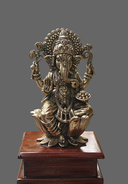 Brass Ganesha idol with arch stand styled on console with decor accessories
