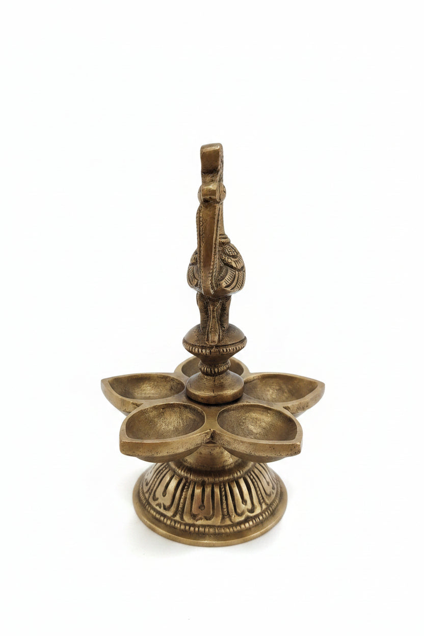 Handcrafted brass peacock diya with 5 petal-shaped oil wicks and intricate engraved base, traditional South Indian temple lamp