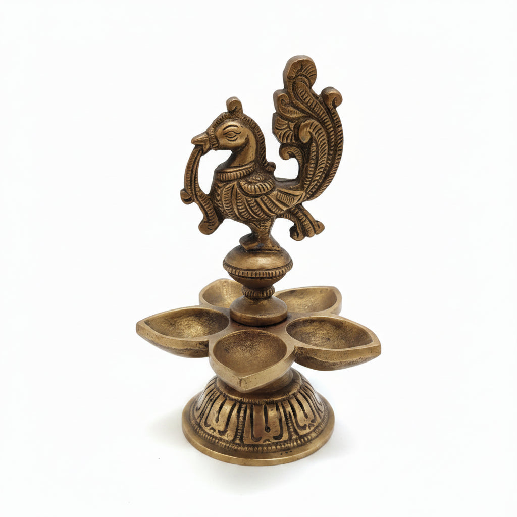 Handcrafted brass peacock diya with 5 petal-shaped oil wicks and intricate engraved base, traditional South Indian temple lamp