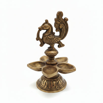 Handcrafted brass peacock diya with 5 petal-shaped oil wicks and intricate engraved base, traditional South Indian temple lamp