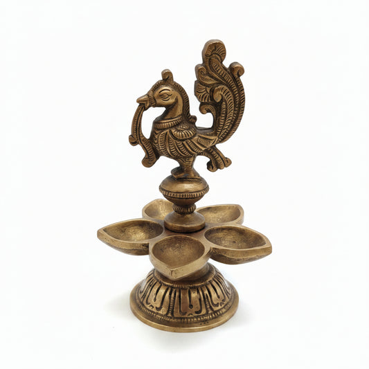 Handcrafted brass peacock diya with 5 petal-shaped oil wicks and intricate engraved base, traditional South Indian temple lamp