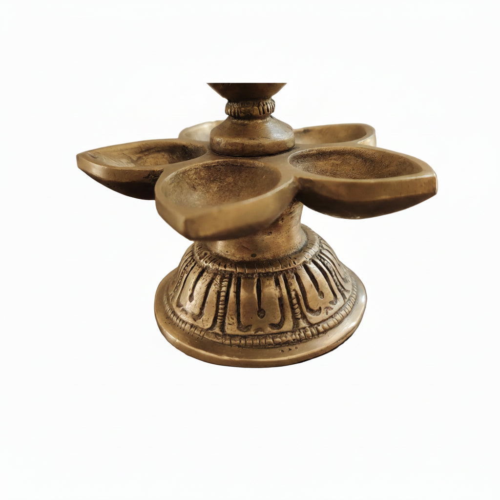 Detailed view of engraved circular base of traditional brass peacock oil lamp