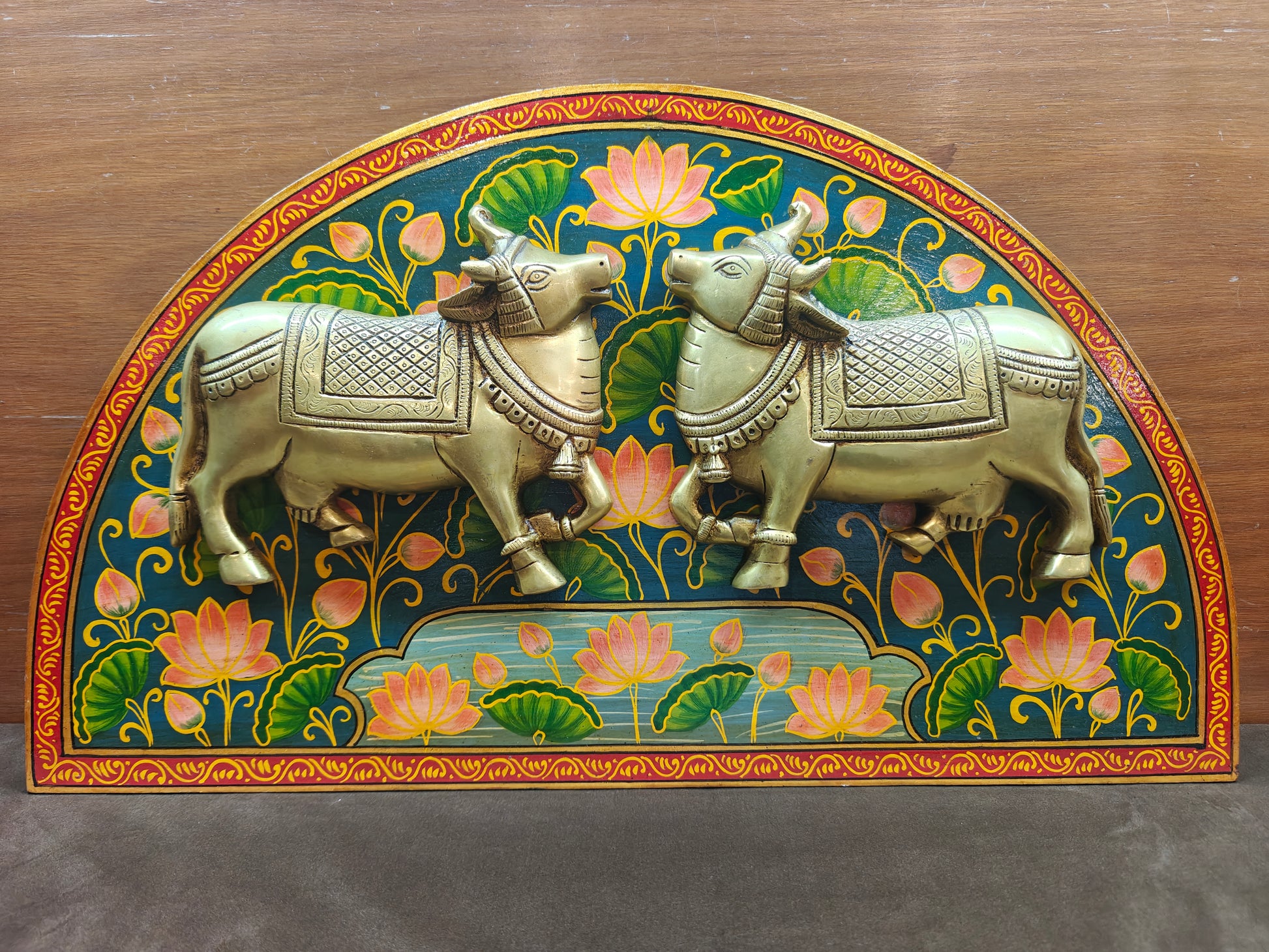 Brass sacred cow wall panel with arched lotus design, 53 x 31 cm