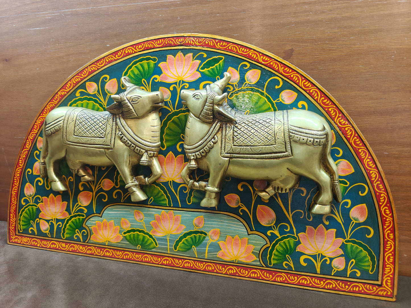 Side view of brass sacred cow wall panel showing depth and relief work