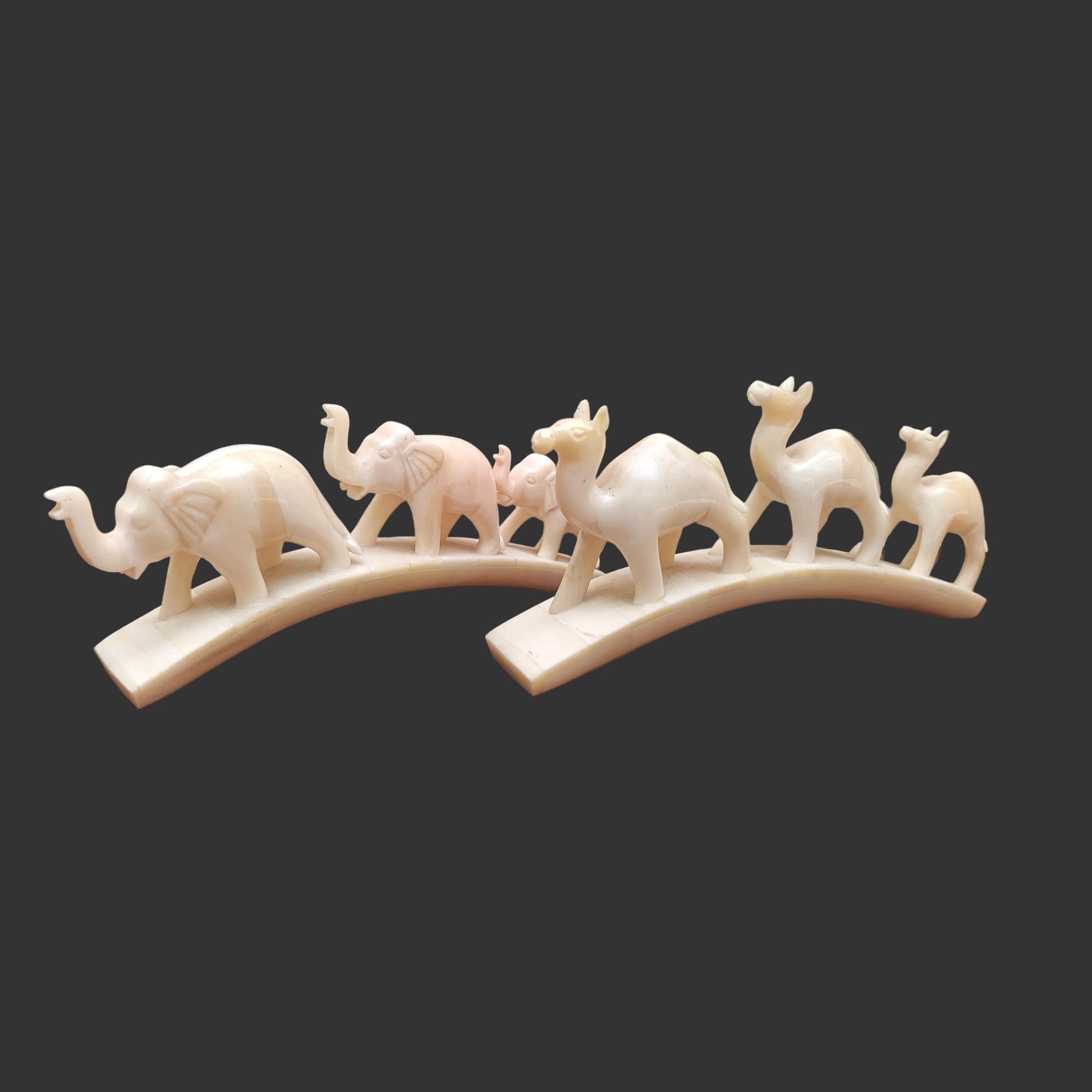 Set of carved bone animal parades with three elephants and three camels on arched bases