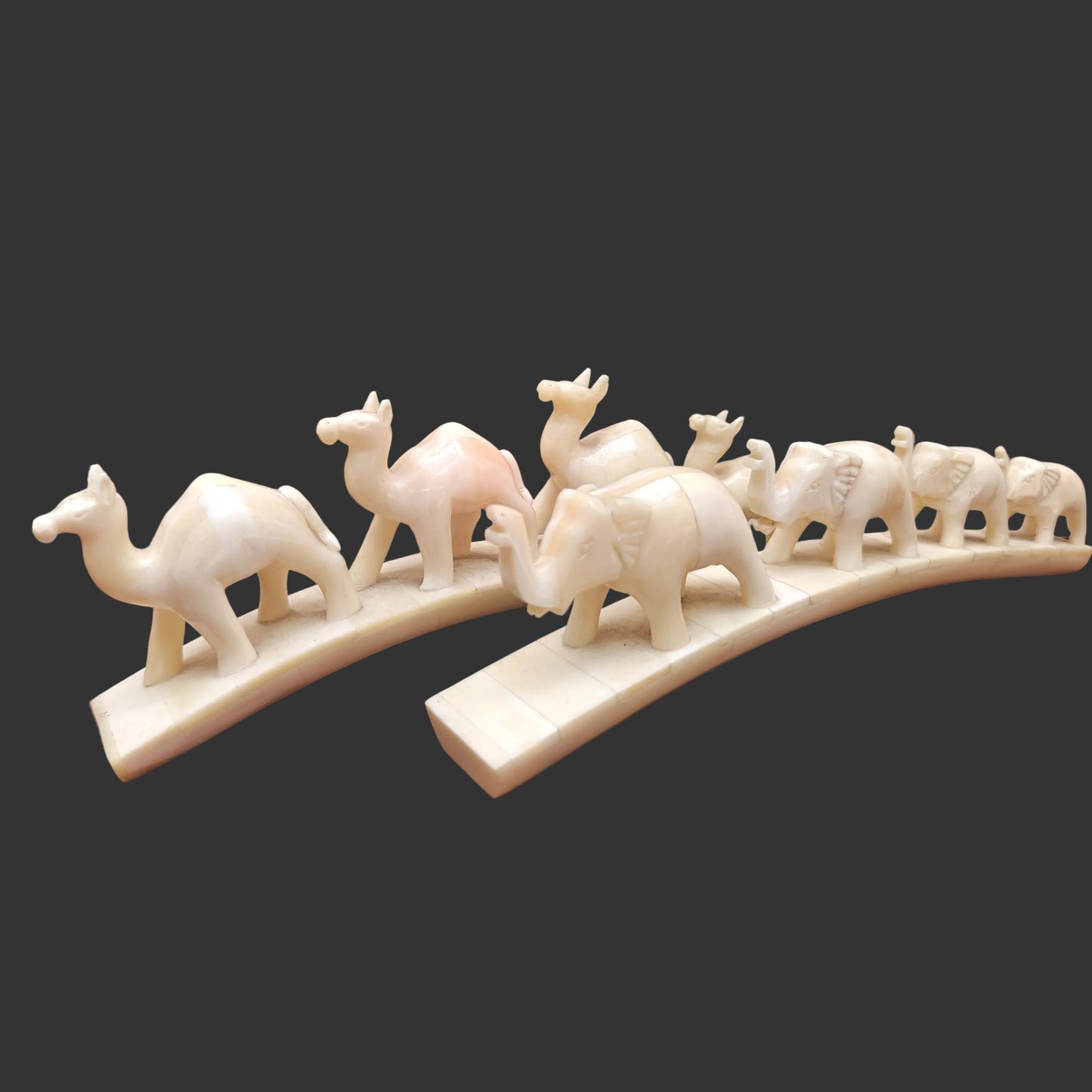 Set of carved bone animal parades with four elephants and four camels on arched bases