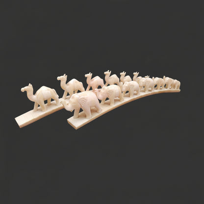 Set of carved bone animal parades with elephant and camel designs on arched bases