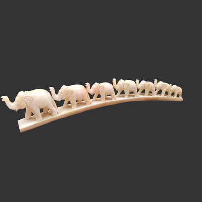 Carved bone elephant parade on arched base displayed