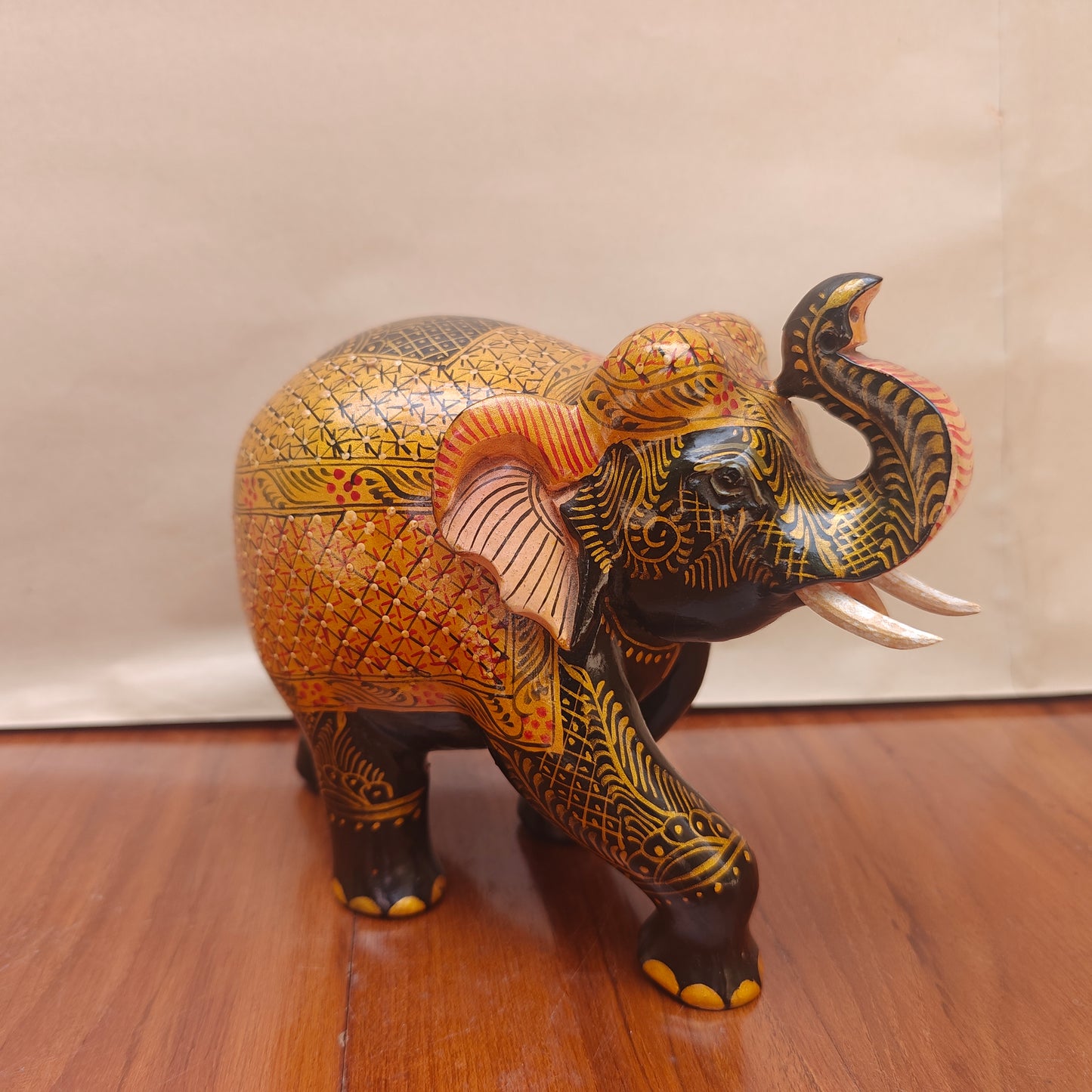 Side view of handpainted black and ochre decorative elephant with traditional patterns

