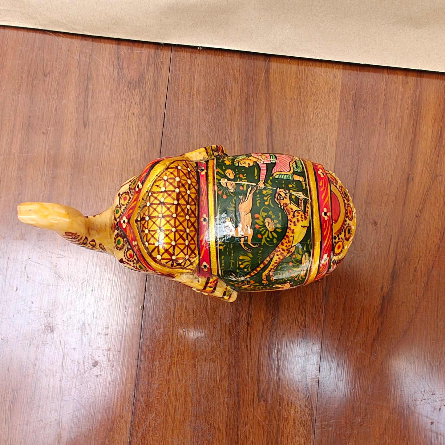 Detail of colourful storytelling artwork on saddle of handpainted bone elephant decor piece