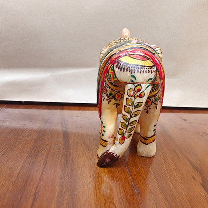 Detail of colourful floral and animal artwork on saddle of handpainted mini bone elephant decor piece