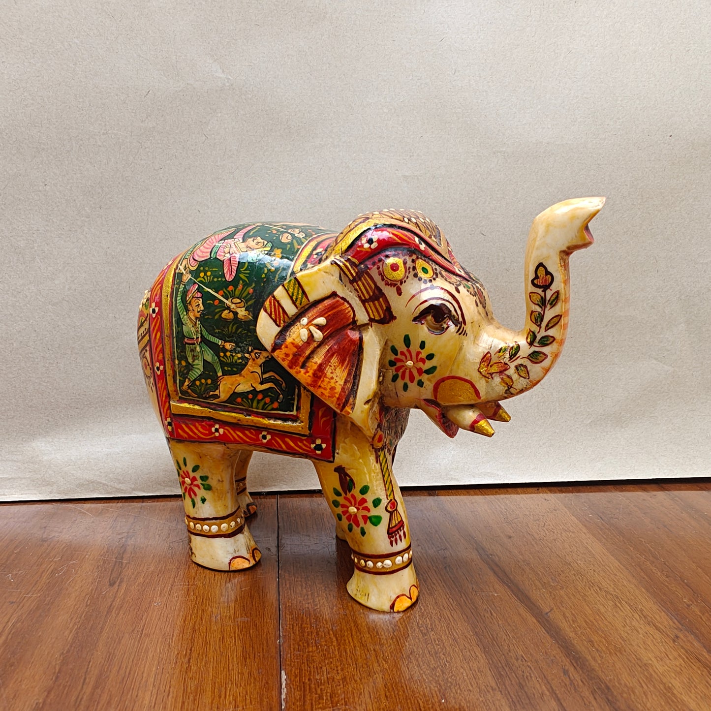 Handpainted miniature bone elephant figurine with storytelling artwork – front side view