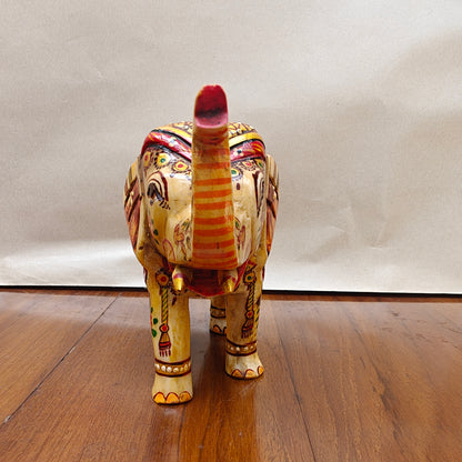 Close-up of painted eyes, ears and raised trunk on miniature bone elephant figurine