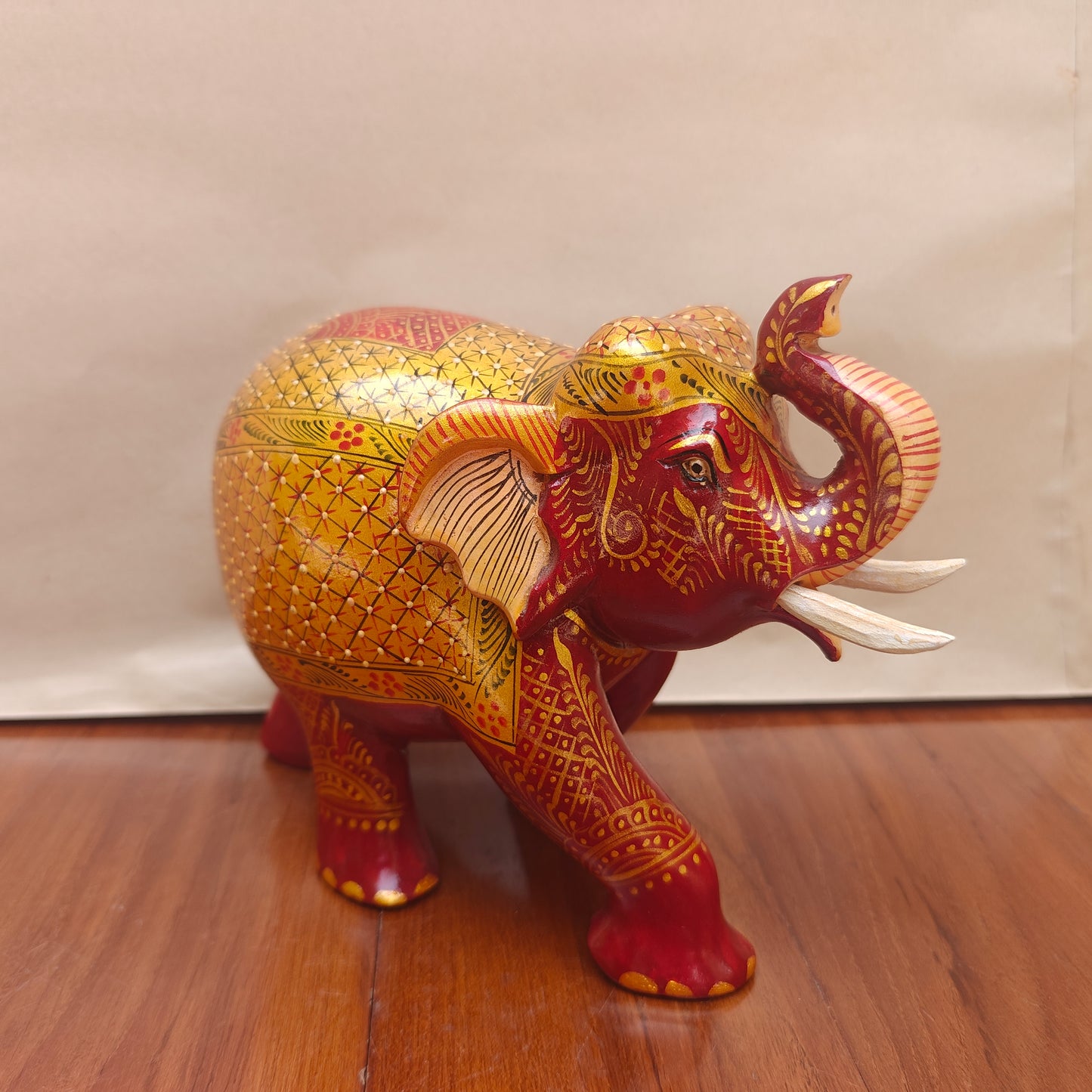 Handpainted red and yellow elephant figurine with golden detailing – front view