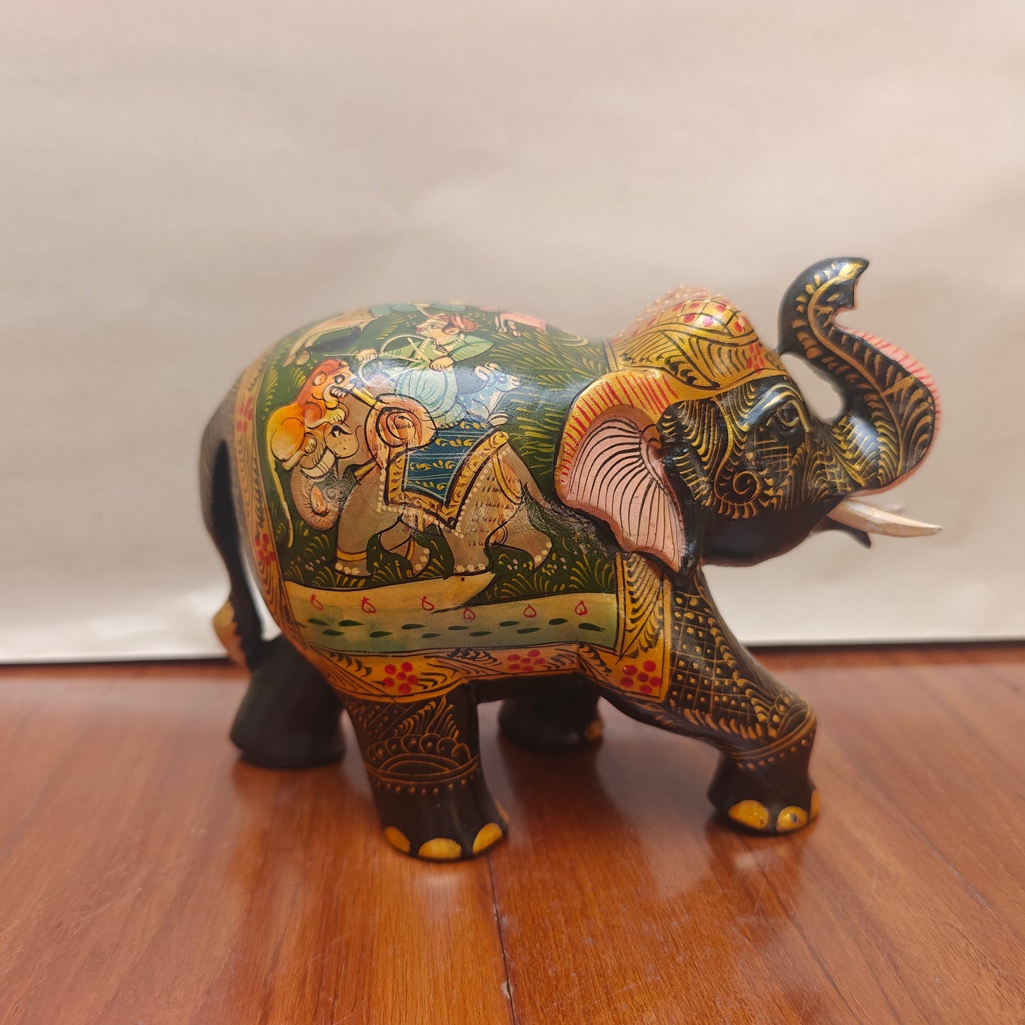 Side profile of handpainted elephant decor showing detailed narrative painting