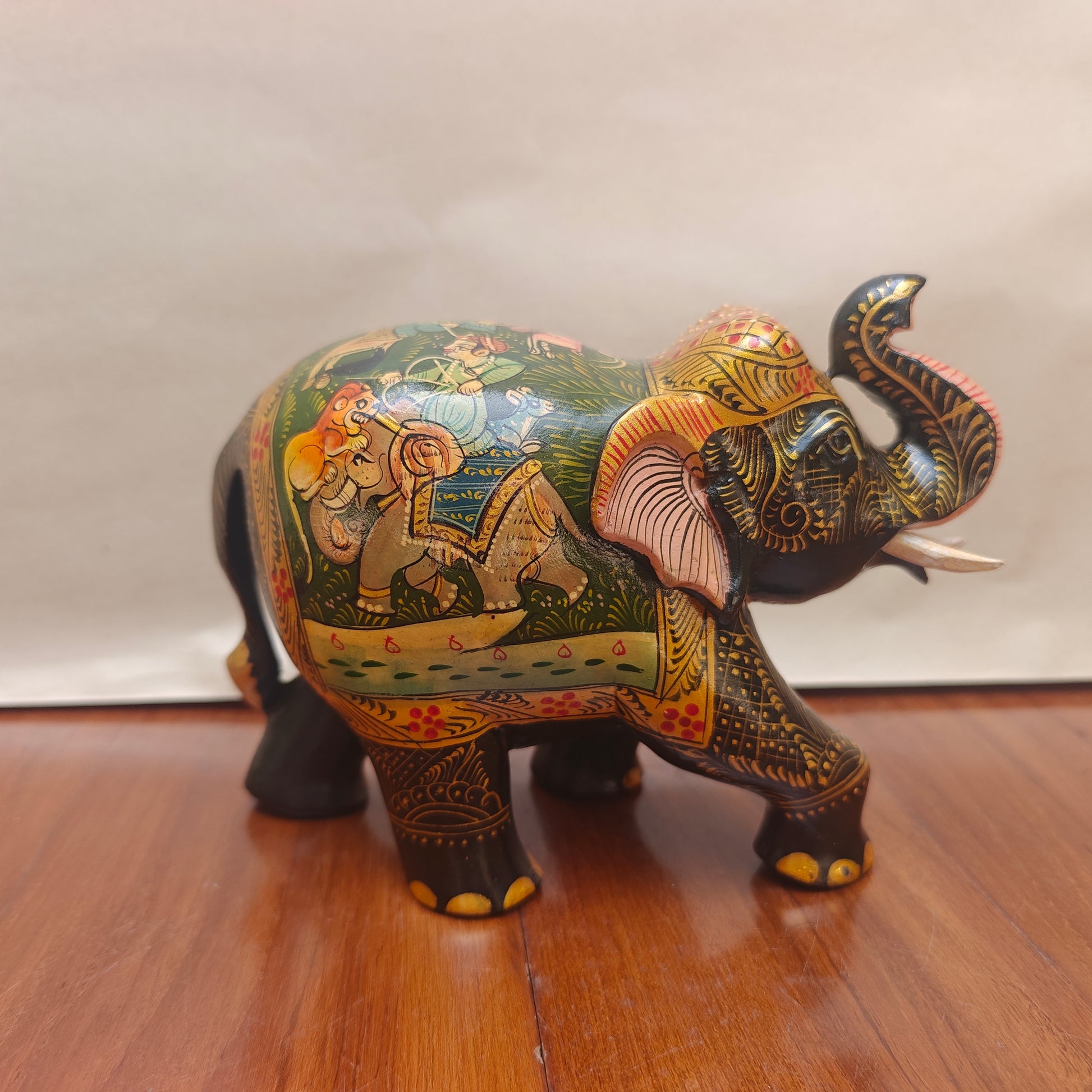 Side profile of handpainted elephant decor showing detailed narrative painting