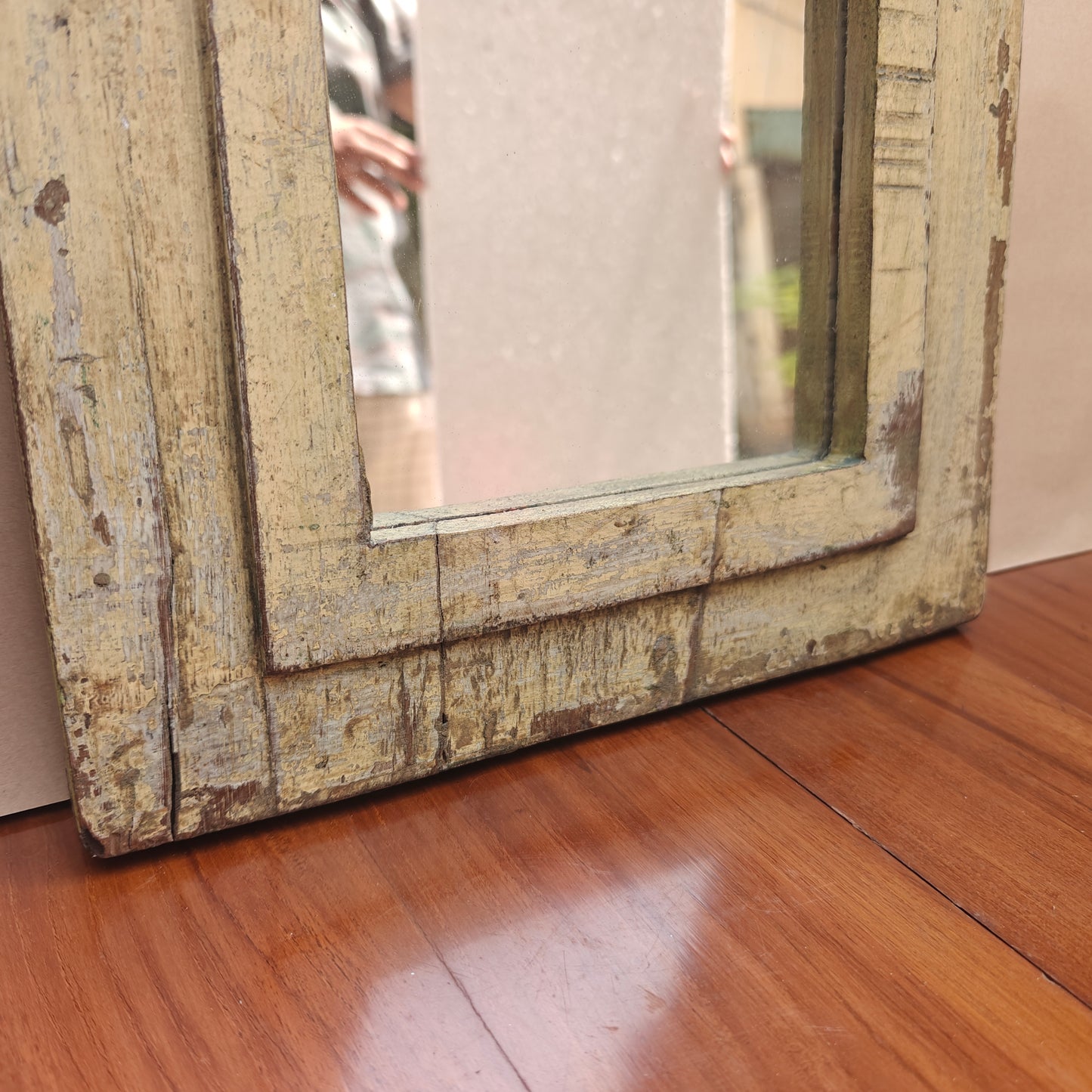 Close up of distressed paint finish and wood grain on Jharokha mirror frame base