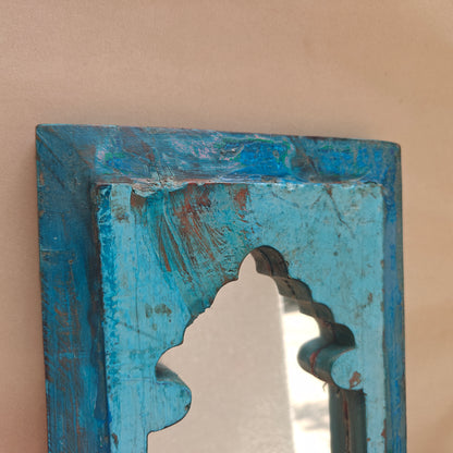 Close up of distressed turquoise paint and wood texture on Jharokha mirror frame corner