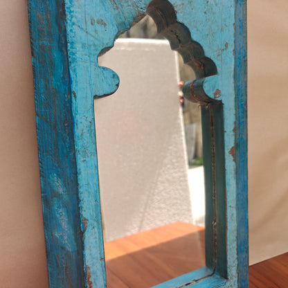 Close up of carved mihrab arch opening on turquoise Jharokha mirror frame