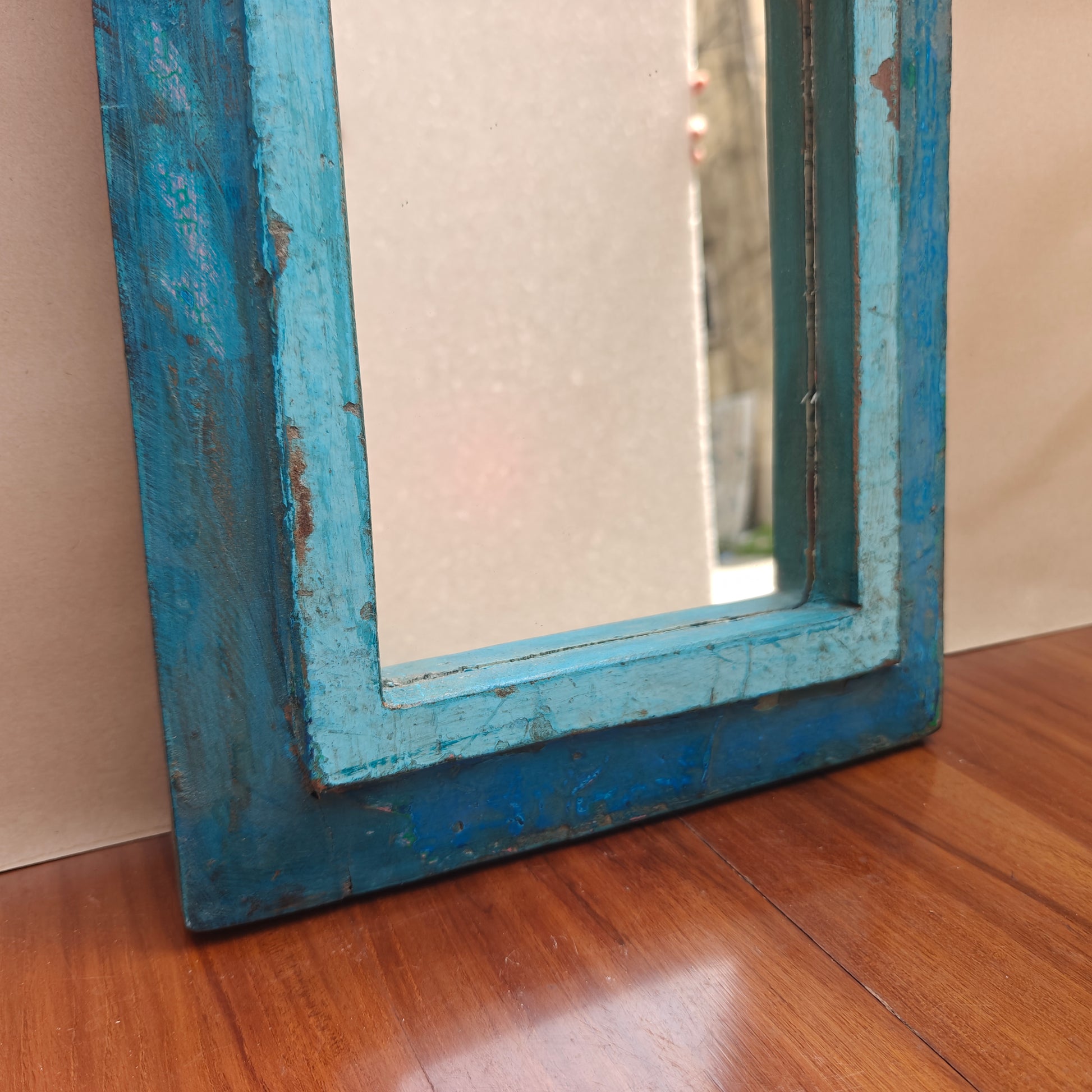 Close up of distressed blue paint finish and wood grain on Jharokha mirror frame base