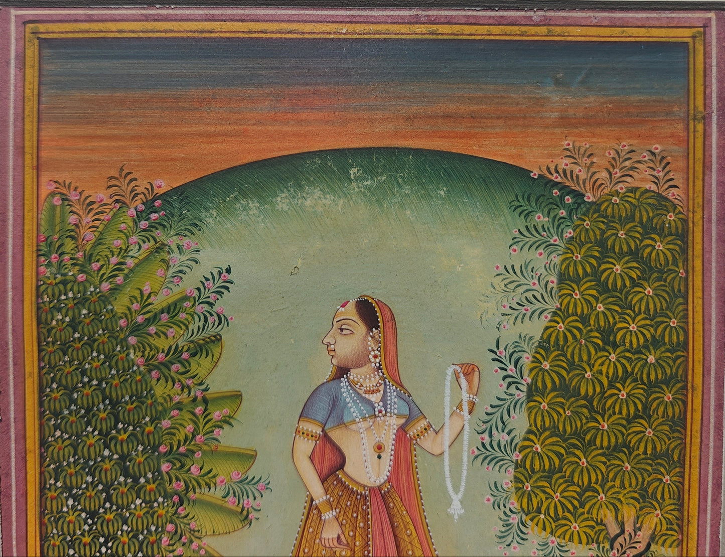 Close-up of lady holding garland in garden scene miniature painting on paper
