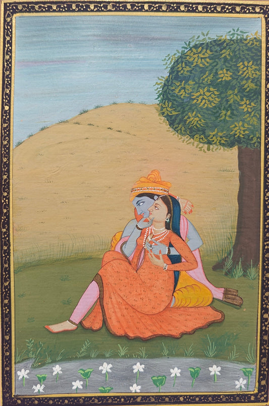 Angled view of Radha Krishna under the tree miniature painting on paper showing pink border