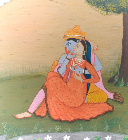 Close-up of Radha and Krishna seated under a tree in miniature painting on paper