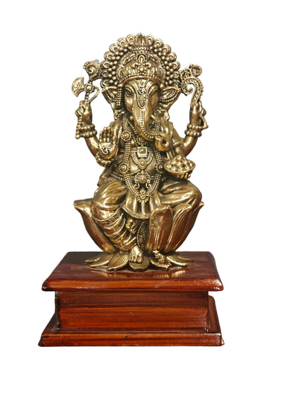 Brass Ganesha idol seated on ornate decorative base, front view