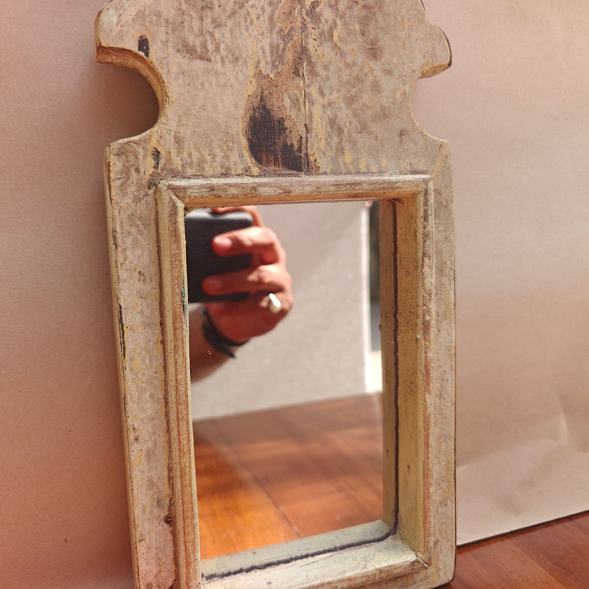 Scalloped crown detail of antique patina wood mirror