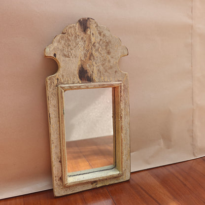 Close-up of mottled antique patina finish on wood mirror frame