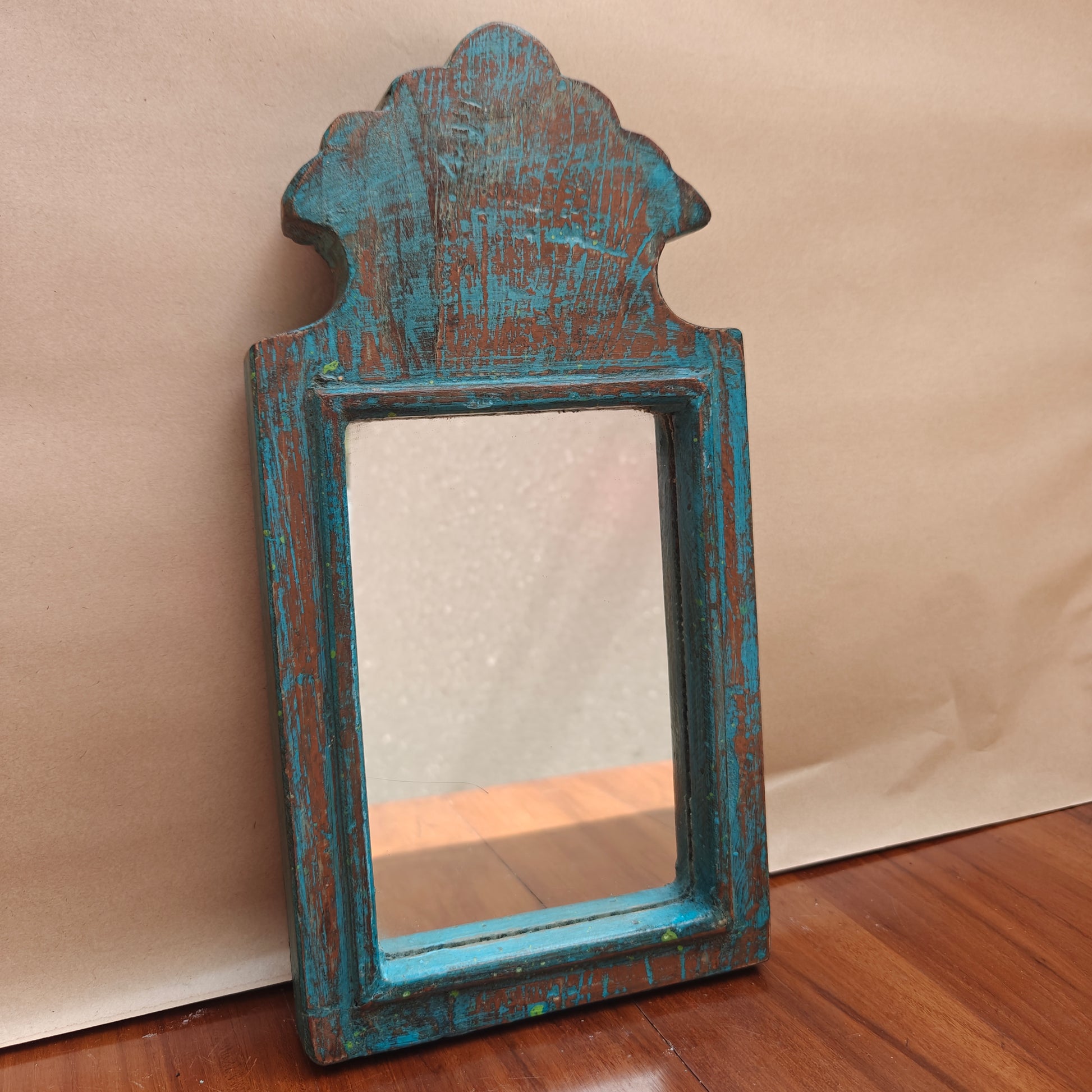 Close-up of weathered blue paint finish on wood mirror frame