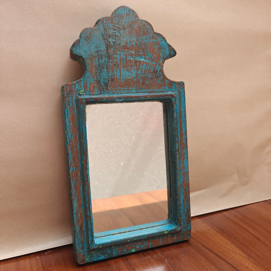 Close-up of weathered blue paint finish on wood mirror frame