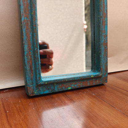 Vintage blue crown-top mirror styled on a console table