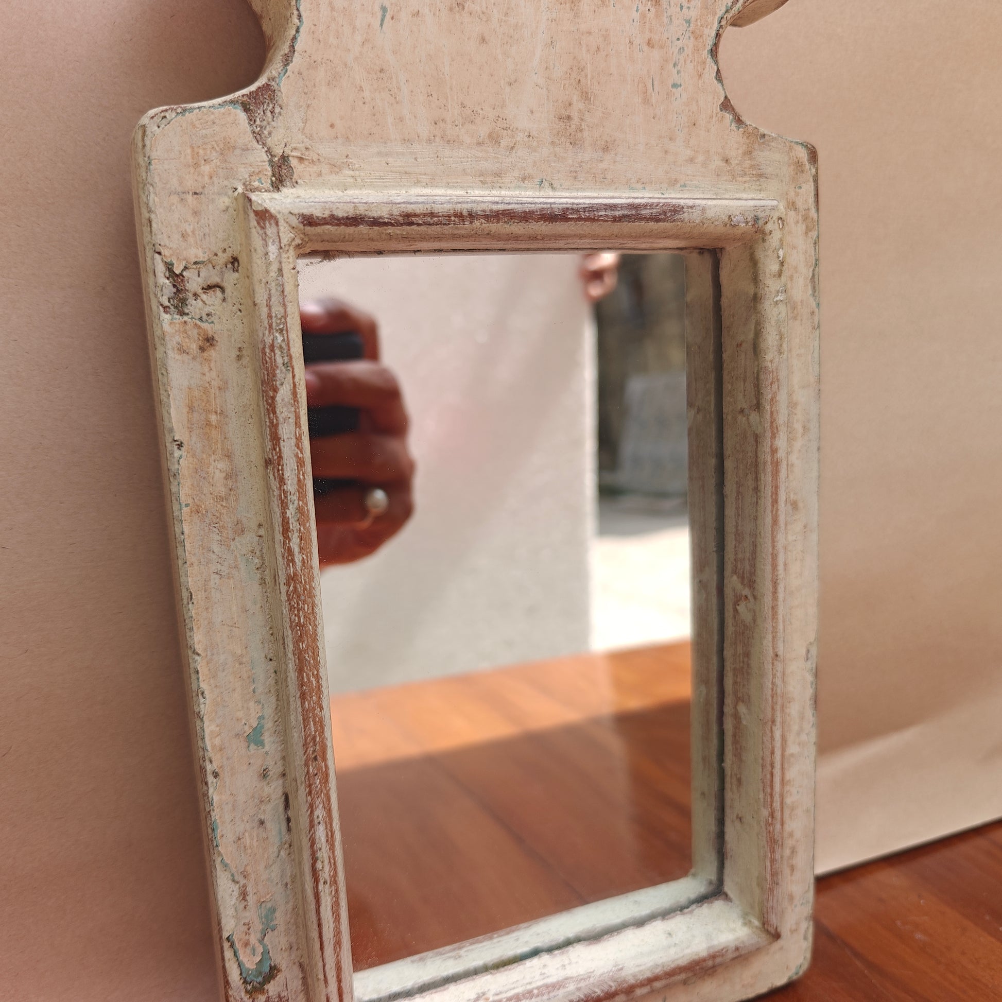 Scalloped crown detail of distressed ivory wood mirror