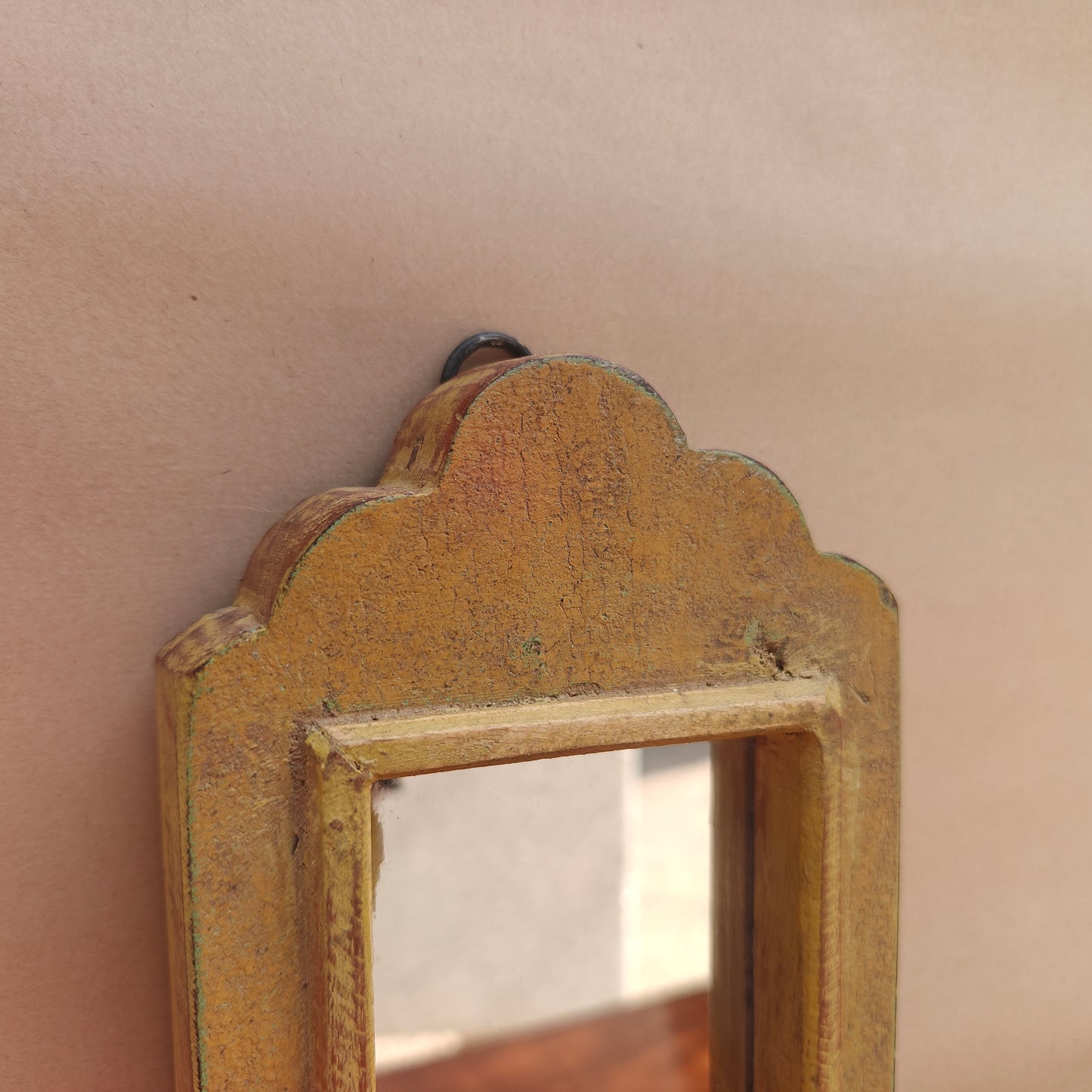 Side profile of vintage mustard crown-top mirror showing frame depth
