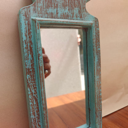 Tiered pointed crown detail of distressed teal wood mirror