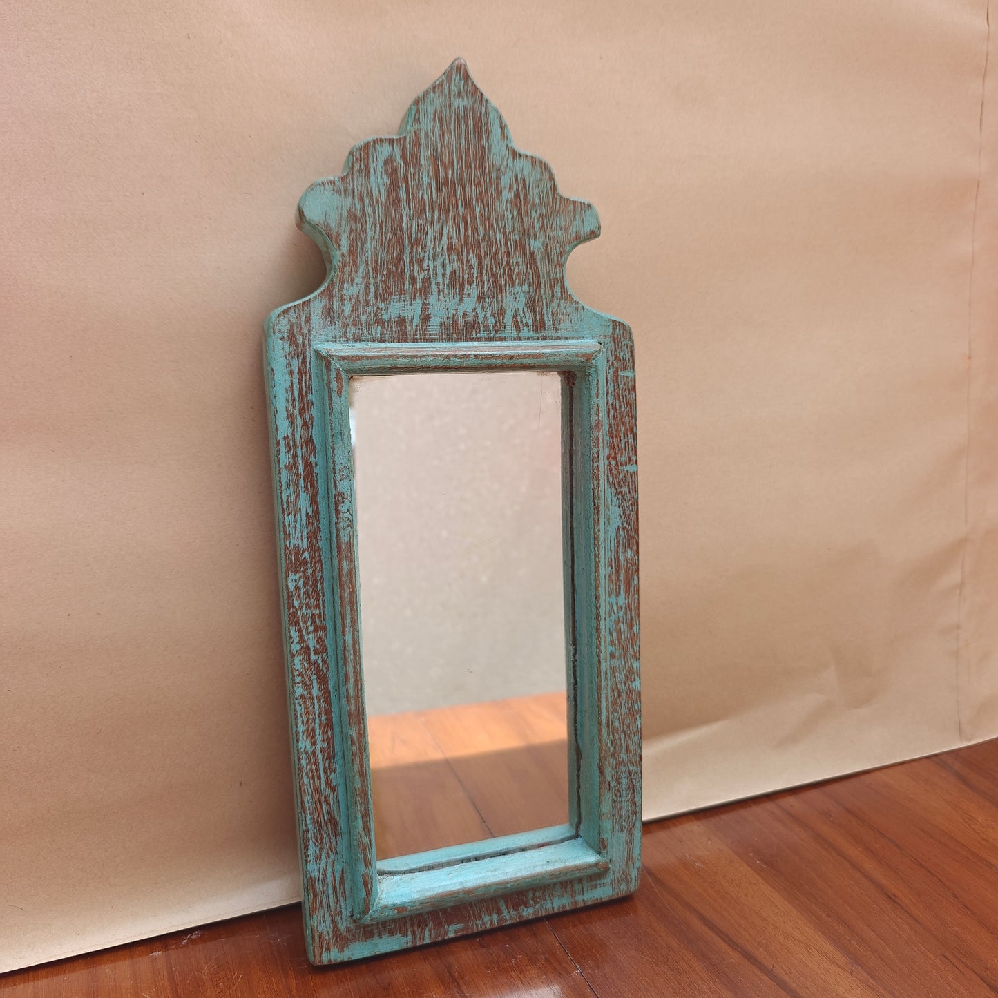 Close-up of weathered teal paint finish showing wood grain