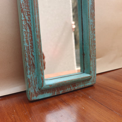 Vintage teal crown-top mirror styled on a console table