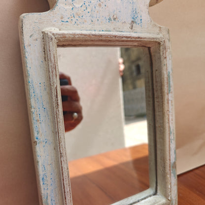 Scalloped crown detail of distressed white wood mirror