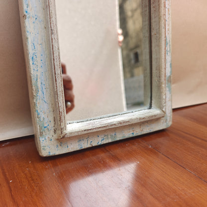 Vintage distressed white mirror reflecting room interior