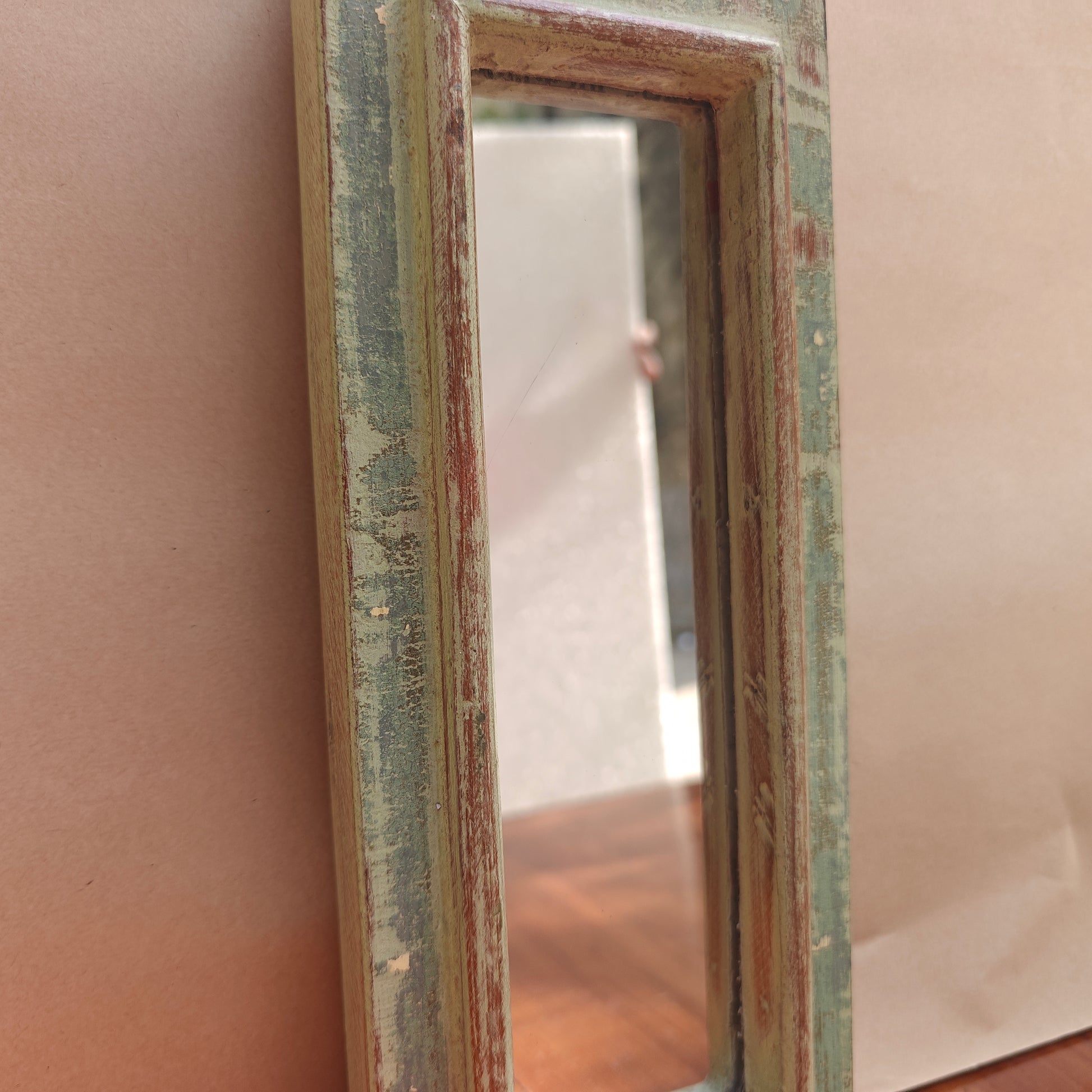 Tall pointed spire crown detail of distressed sage green mirror