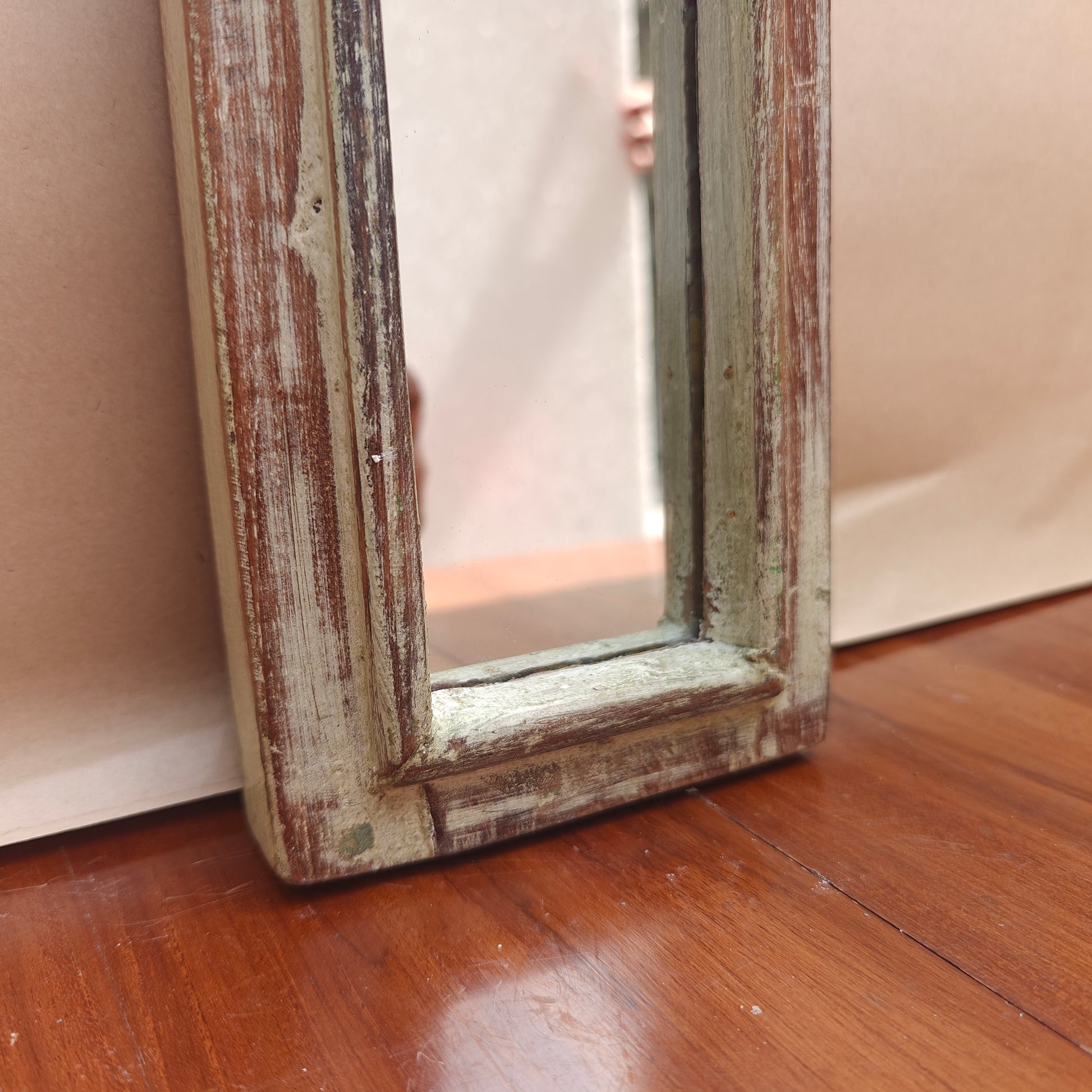 Narrow vintage whitewash mirror styled on a console table