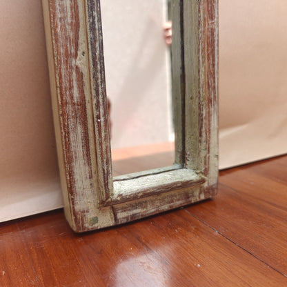 Narrow vintage whitewash mirror styled on a console table